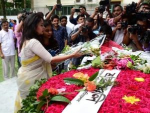 امرأة تضع باقة من الزهور تحية لارواح 22 قتيلا سقطوا في هجوم على مقهى في عاصمة بنغلادش دكا

