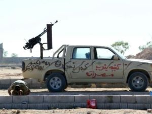 مقاتل ليبي تابع لحكومة الوحدة الوطنية يصلي قرب سيارة عسكرية في سرت
