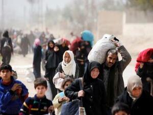 أشخاص يحملون أغراضهم بينما يفرون من بلدة حمورية الخاضعة لسيطرة المعارضة في الغوطة الشرقية
