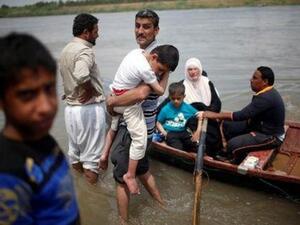 نازحون عراقيون يستعدون لعبور نهر دجلة في قارب بعد أغلاق جسر بشكل مؤقت في غرب الموصل

