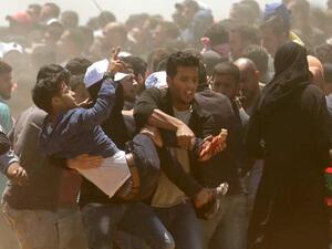 فلسطينيون يحملون جريحا اصيب برصاص القوات الاسرائيلية على حدود غزة