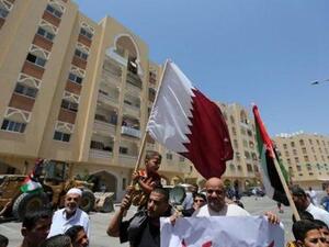 رجل يحمل علم قطر في قطاع غزة 
