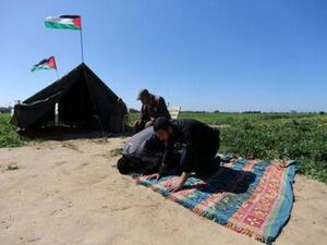 فلسطينيون يؤدون الصلاة بجوار خيمة بالقرب من الحدود مع اسرائيل
