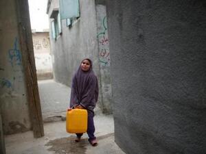 فتاة فلسطينية تحمل مياه في علبة بلاستيكية في شمال غزة
