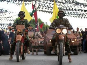 أفراد من حزب الله اللبناني يستقل دراجات نارية ومركبات خلال عرض في قرية بجنوب لبنان
