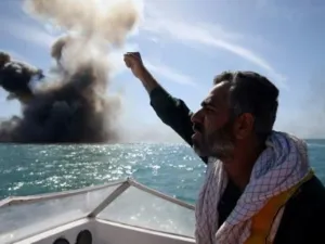 عضو من قوات الحرس الثوري الإيراني يطلق الشعارات خلال تدريبات عسكية في مضيق هرمز
