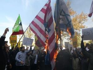 متظاهرون ايرانيون يحرقون ما يشبه الأعلام الاميركية والاسرائيلية في طهران

