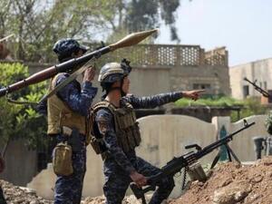 اثنان من أفراد الشرطة الاتحادية العراقية ينظران إلى مواقع للدولة الإسلامية
