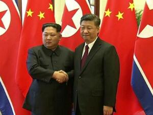 لقطة بثها التلفزيون الحكومي الصيني للزعيم الكوري الشمالي كيم جونغ اون والرئيس الصيني شي جينبينغ في بكين
