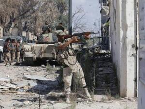 أحد أفراد الجيش الوطني الليبي يطلق النار أثناء اشتباك مع مقاتلين إسلاميين في معقلهم الأخير في بنغازي يوم الخميس
