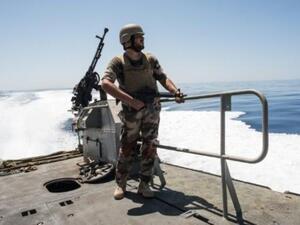 عنصر من خفر السواحل الليبي يقف على متن قارب في منطقة بين صبراتة والزاوية في المياه الإقليمية الليبية
