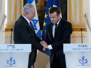 الرئيس الفرنسي إيمانويل ماكرون (إلى اليمين) يصافح رئيس وزراء إسرائيل بنيامين نتنياهو خللال مؤتمر صحفي في باريس يوم الأحد
