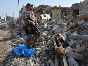 عنصر من جهاز مكافحة الارهاب يقف في موقع تعرض لتدمير بعد ضربة جوية ضد تنظيم الدولة الاسلامية في الموصل
