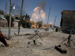 أحد افراد قوات الرد السريع العراقية يطلق قذيفة هاون على مواقع لمقاتلي تنظيم الدولة الاسلامية في غرب الموصل

