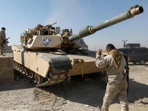 أحد أفراد قوات الأمن العراقية يوجه دبابة في الجزء المحرر من قرية أبو سيف جنوب الموصل 
