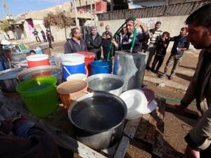 عراقيون يحصلون على الماء في الموصل بشمال العراق
