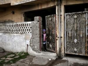 طفلة تطل خلف بوابة في الموصل خلال عملية للقوات العراقية لاستعادة الجزء الغربي للمدينة من الجهاديين

