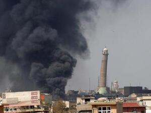 الدخان يتصاعد قرب مأذنة الهضبة بالمسجد الكبير في المدينة القديمة بالموصل يوم الجمعة
