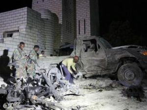 جنود ورجال شرطة صوماليون يعاينون موقع هجوم إنتحاري بسيارة ملغومة قرب البرلمان في العاصمة مقديشو يوم السبت
