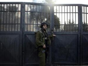جندي اسرائيلي يقف عند مدخل المدرسة
