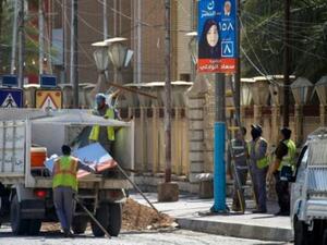 عمال البلدية يزيلون لوحات دعائية للمرشحين في مدينة النجف غداة الانتخابات
