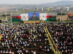 الأمين العام لجماعة حزب الله اللبنانية حسن نصر الله يخاطب تجمعا لمناصريه عبر شاشة عملاقة في إحدى القرى في جنوب لبنان بالقرب من الحدود مع إسرائيل يوم الجمعة
