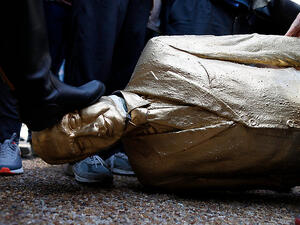 امراة تدوس التمثال بقدمها

