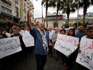 فلسطينيون يشاركون في احتجاج يطالب برفع "الإجراءات العقابية عن غزة" في رام الله يوم الثلاثاء

