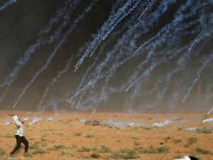 قنابل غاز مسيل للدموع ألقتها قوات إسرائيلية على محتجين فلسطينيين على الحدود مع غزة يوم الجمعة

