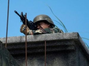 جندي فيلبيني يصوب سلاحه نحو مواقع المسلحين الإسلاميين من فوق سطح بناية في مدينة ملاوي

