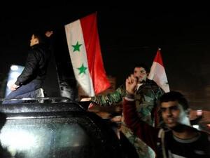 أنصار الرئيس السوري بشار الأسد يحملون اعلامهم الوطنية ويحتفلون بما اعتبروه انتصار الجيش السوري في حلب يوم الاثنين
