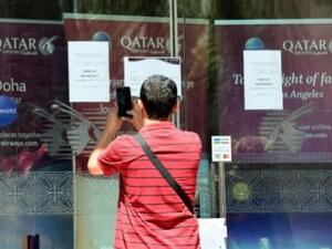 يلتقط صور لإشعارات باقفال مكتب الخطوط القطرية في الرياض
