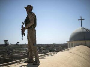 جندي عراقي يحرس كنيسة مار يوحنا خلال قداس الفصح في بلدة قرقوش قرب الموصل

