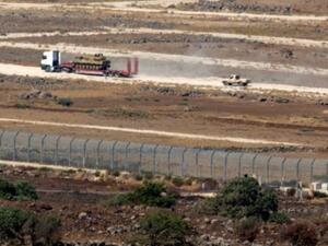 صورة التقطت من القسم المحتل من هضبة الجولان السورية لمدرعة تابعة للفصائل السورية المعارضة خلال نقلها في محافظة القنيطرة
