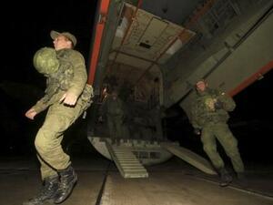 نود روس لدى عودتهم من قاعدة حميميم السورية إلى مطار عسكري بالقرب من ميناء سيفاستوبول الروسي بالقرم
