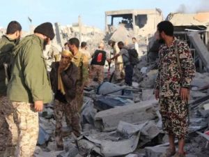 مقاتلون من القوات الليبية المتحالفة مع الحكومة المدعومة من الأمم المتحدة عند حطام منزل في سرت
