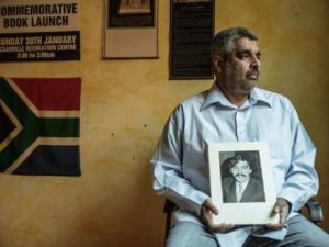 قريب يحمل صورة احمد تيمول في 25 ايار/ماي 2015 الذي كان مناضلا ضد نظام الميز العنصري وقضى في ظروف مشبوهة اثر احتجازه في مقر قيادة الشرطة بجوهانسبورغ في 1971.

