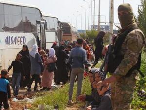 مقاتل من المعارضة قرب حافلات تنتظر لنقل سكان من قريتي الفوعة وكفريا في إدلب 
