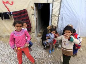 أطفال سوريون أمام خيمة في بير الياس بسهل البقاع اللبناني
