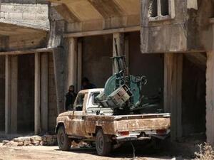 مقاتل بالجيش السوري الحر يقف بجوار سيارة مثبت عليها مدفع مضاد للطائرات في القنيطرة
