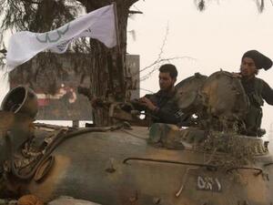مقاتلان من المعارضة السورية فوق مركبة عسكرية في غرب حلب
