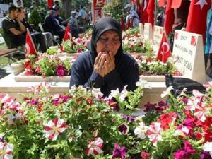 سيدة تركية تتلو الفاتحة امام قبر قريب لها قتل خلال المحاولة الانقلابية في تركيا قبل عامين بالتمام
