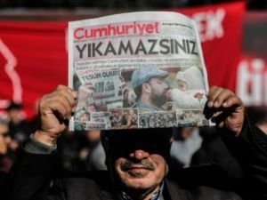 متظاهر يرفع نسخة من صحيفة "جمهورييت" امام مقر الصحيفة في اسطنبول

