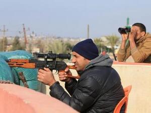 أحد عناصر القوات العراقية يوجه سلاحه إلى الضفة الأخرى لنهر دجلة في الموصل
