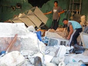 رجلان يقفان بين حطام ناتج عن غارة جوية على مستشفى في غربي إدلب
