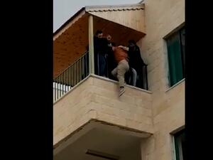 صورة من الفيديو تظهر اشخاصا يمنعون الطالبة من القاء نفسها من مبنى داخل الجامعة