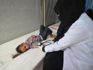 ممرضة تفحص طفلا مصابا بالكوليرا داخل مستشفى في الحديدة باليمن
