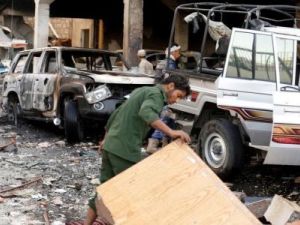 أناس يعاينون الأضرار التي لحقت بالقرب من موقع ضربة جوية يقول شهود إن التحالف الذي تقوده السعودية شنها لاستهداف دار عزاء في العاصمة صنعاء
