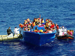 Italian navy rescuers help refugees to climb on to their boat in the Mediterranean. (AFP/Getty Images)