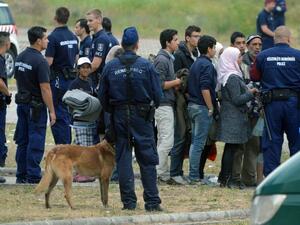 This file photo taken on June 25, 2015 shows asylum-seekers waiting to board a bus at the Hungarian-Serbian border to transport them to a new refugee camp on June 25, 2015. (AFP/Csaba Segesvari) 